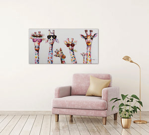 An der Wand hängt eine Gemälde auf dem bunte Griaffen mit Sonnenbrillen zu sehen sind. Die Giraffenfamilie schein eine Party zu feiern. Unter dem Gemälde steht ein rosa Sessel