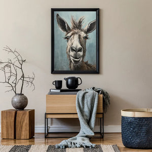 An einer grauen Wand hängt ein Bild von einem lachenden Esel