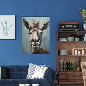 An einer blauen Wand hängt das Gemälde mit einem lächelnden Esel. Wer dieses Gemälde im Wohnzimmer hat braucht kein Eseltrekking mehr.