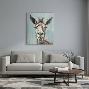 In einem modernen Wohnzimmer hängt eine Gemälde von einem Esel über der grauen Sitzgarnitur. Der Esel sieht zufrieden aus und bringt Ruhe in das Wohnzimmer