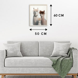 An einer wand hängt ein Bild von drei Lamas. Daneben stehen die Maße von 50 x 60 cm