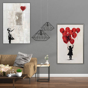 Zwei Gemälde mit roten Luftballons hängen an einer Wand. Auf beiden Gemälden lassen die Mädchen die Luftballons steigen und blicken zum Himmel.