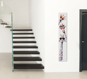 In einem Flur hängt ein schmales Bild mit drei bunten Giraffen drauf