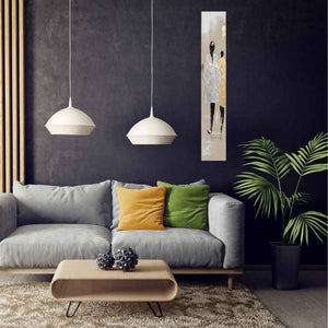 Ein schmales Bild mit zwei Models auf einer Modenschau in den Farben Gold und Silber hängt an einer dunkelblauen Wand im Wohnzimmer.