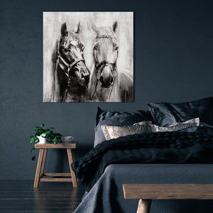 Ein Gemälde von zwei Pferdeköpfen hängt an einer blauen Wand.