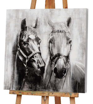 Ein Gemälde von einem Schimmel und einem Rappen steht auf einer Staffelei