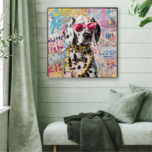 Im Esszimmer hängt ein quadratisches, farbenfrohes Gemälde mit Rahmen. Auf dem Hundegemälde sieht man einen Dalmatiner mit Brille und Goldketten.