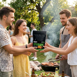 Ein Produktbild zeigt eine schwarze Tüte handgemachtes "Party Upgrade" Gourmet-Popcorn vor einer Gruppe ausgelassener, tanzender Menschen auf einer Party. Die Tüte hat ein hellgrünes Etikett mit weißer und schwarzer Schrift und einer Abbildung des Popcorns.