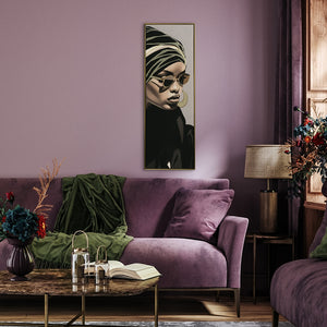 Auf einer lila Wand im Wohnzimmer hängt ein Schwarz Goldenes Frauenporträt. Das schmale Acrylgemälde zeigt einen mondänen Lifestyle.