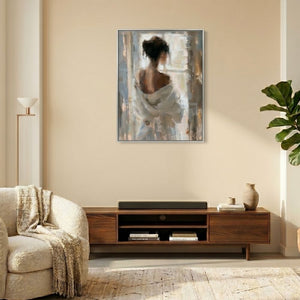 Über einem Sideboard an einer aprikotfarbenen Wand hängt ein farblich passendes Acrylgemälde. Auf dem Bild ist eine Frau im Bademantel zu sehen die aus dem Fenster schaut. Die Frau auf dem Gemälde hat einen schönen Rücken.