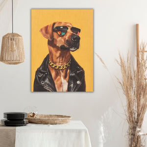 An der weißen Wand im Esszimmer hängt ein gelbes Bild. Ein Rhodesian Ridgeback Rüde mit Sonnenbrille, Lederjacke und Goldkette schaut stolz von dem Geälde.