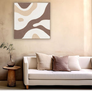 An einer sandfarbenen Wand hängt ein Gemälde welches aussieht als wenn ein Vanilleeis mit Karamell und Schokolade auf ihm verlaufen wäre.