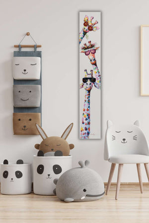 In einem Kinderzimmer oder einer Arztpraxis ist das schmale Bild mit den drei bunten Giraffen sehr beliebt