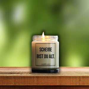 Auf einem gartentisch steht die Duftkerze mit der Aufschrift "Scheiße bist Du alt" Geburtstagsüberraschung