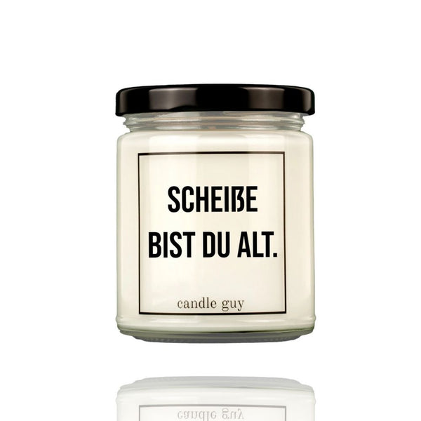 Auf einer Geburtstagskerze im Glas steht der Spruch "Scheiße bist Du alt" Die Duftkerze ist von Candle Guy