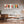 Modernes, schmales Gemälde im Querformat als Wandbild im Esszimmer über dem Esstisch. Das abstrakte Kunstwerk mit buntem Modenschau-Motiv ergänzt die stilvolle Einrichtung mit Designer-Stühlen.