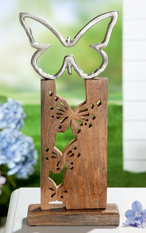 Aus einem Stück Holz sind drei Schmetterlinge ausgeschnitten und auf dem Holzstück ist ein Schmetterling aus Aluminium. Die Skulptur trägt den Namen Butterfly Standrelief und ist ein schönes Dekoelement für die Wohnung oder den Wintergarten.