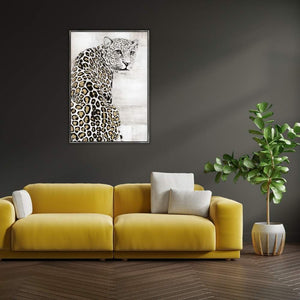 Das Acrylgemälde Schneeleopard hängt an einer dunklen Wand über dem gelben Sofa im Wohnzimmer. Der Schneeleopard wird auch Irbis oder Unze genannt und ist sehr selten.