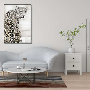 An einer weißen Wand im Wohnzimmer hängt ein weißer Schneeleopard über der weißen Couch oder Sitzgarnitur.