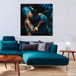 An der Wand hangt eine Gemälde mit einer wunderschönen Frau die auf der Hand einen  blauen Papagei trägt. Das Gemälde passt hervorragend zur Couch die sich darunter befindet.