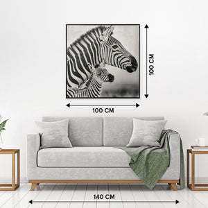 An der weißen Wand stehen die Maße von einem Bild mit zwei Zebras. darunter steht ein Sofa.