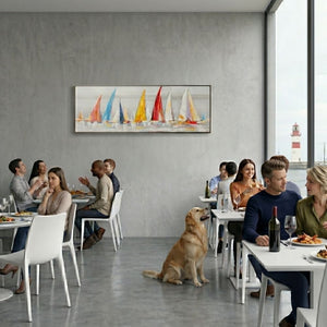 Panorama-Wandbild mit bunten Segelbooten im modernen maritimen Stil an der grauen Wand eines Restaurants. Abstraktes maritimes Kunstwerk über Gästen, die an weißen Tischen essen.