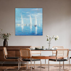 Eine stilvolle Raumansicht in einem modernen Esszimmer, die das große, quadratische maritime Gemälde mit Segelbooten als Wanddekoration präsentiert. Das Kunstwerk hängt zentriert an einer schlichten, beigefarbenen Wand über einem einladend gedeckten Esstisch aus Holz. Um den Tisch stehen vier Freischwinger-Stühle mit charakteristischem Geflecht aus Wiener Geflecht und verchromten Rohrrahmen. Links im Hintergrund ist ein Sideboard aus dunklem Holz zu sehen, auf dem eine dunkle Vase mit zarten Blumen steht.