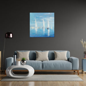 Ein quadratisches Acrylgemälde an einer dunkelgrauen Wand über einem hellblauen Sofa. Das Bild zeigt mehrere weiße Segelboote, die auf ruhigem, blauem Wasser treiben und sich darin spiegeln. Ein hellblauer Himmel mit einigen Wolken bildet den Hintergrund. Die Szene ist von einer beruhigenden, maritimen Atmosphäre geprägt.