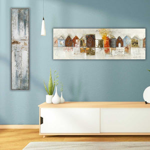 An einer türkisen Wand hängen zwei Gemälde die passend auf die Farbe der Wand abgestimmt sind. Abstraktes Gemälde in den farben Silber, Weiß und Blau und ein Gemälde mit Blechhäuser.