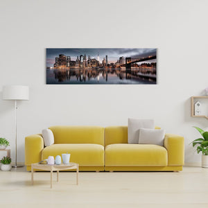 Bild von der Skyline Manhattan im Abendlicht. Der Financial District mit seinen Hochhäusern ist schön beleuchtet.