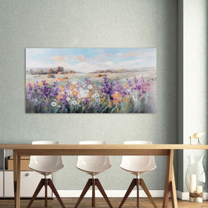 Ein Tisch, drei Stühle und an der Wand ein Gemälde von der Toskana oder der Provance. Eine üppige Blumenwiese mit ein paar Häusern sieht man auf dem Gemälde.
