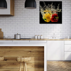 Ein Bild von zwei Paprika die ins Wasser fallen hängt in einer Küche. Das Bild wirkt frisch, natürlich und ist ein Bild welches auch Veganer lieben.