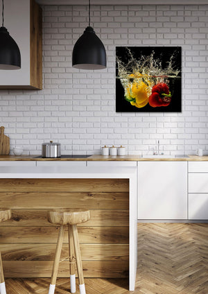 Ein Bild von zwei Paprika die ins Wasser fallen hängt in einer Küche. Das Bild wirkt frisch, natürlich und ist ein Bild welches auch Veganer lieben.