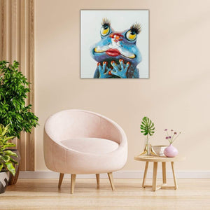 Über einem rosafarbenen Sessel ist ein Gemälde von einer Froschdame die sehr verliebt schaut.