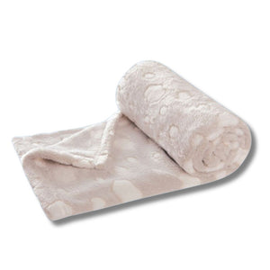 Die weiche Kuscheldecke in der Farbe Beige ht weiße Wolken als Muster. Sie ist auf diesem Bild aufgerollt.