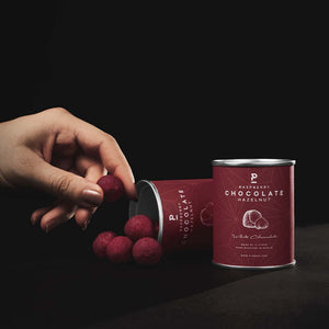 Haselnüsse ummantelt von weißer Schokolade und rotem Himbeerpulver. P-Stash Nüsse aus Berlin.