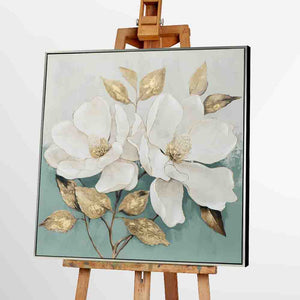 Ein Blumengemälde zeigt zwei Magnolienblüten. Das gerahmte Bild steht auf einer Staffelei.