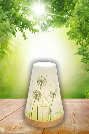 Windlicht aus Keramik mit grünen Pusteblumen. Das Windlicht steht auf einem Holzteller und ist ideal für eine Frühling oder Sommer Tischdekoration.