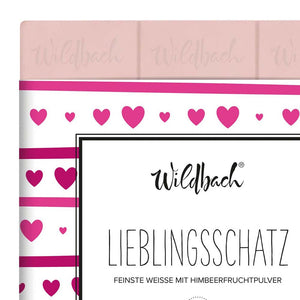 Rosa Schokolade mit einer Herzverpackung von Wildbach. Auf der Verpackung steht der Spruch Lieblingsschatz